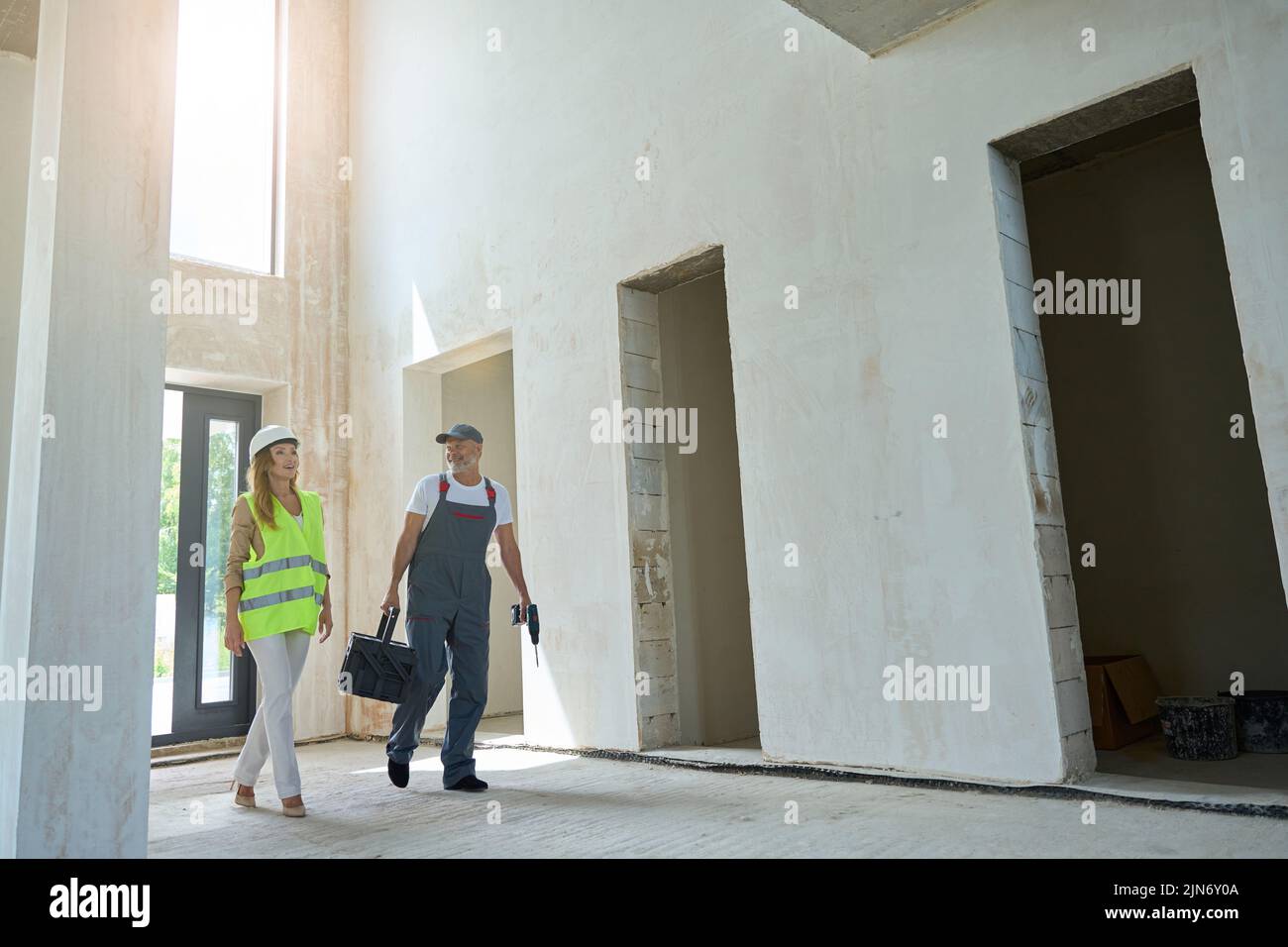 Builder holding drill and tool box fun chatting with agent Stock Photo