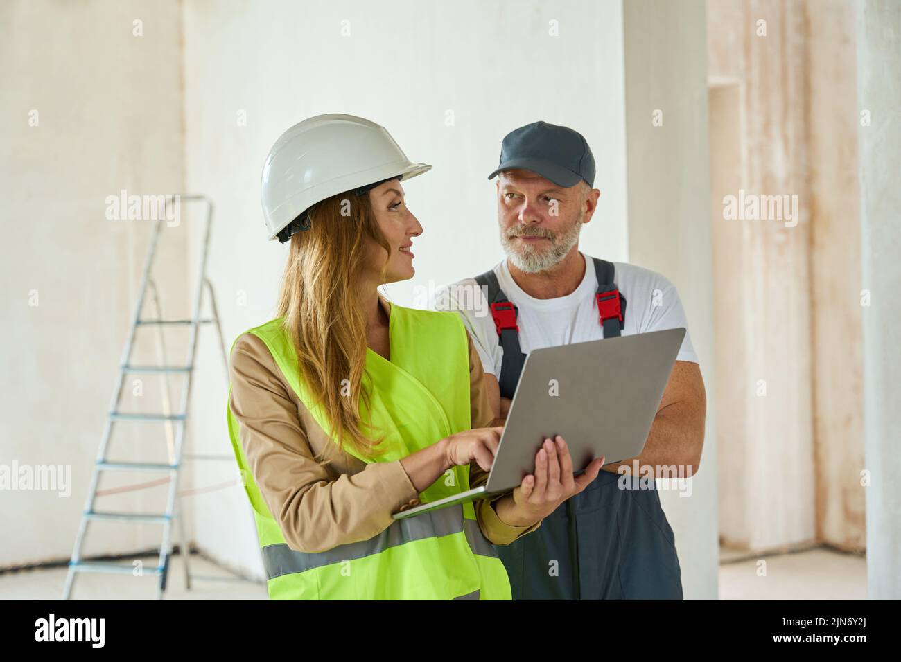 Agent communicates with adult worker hold open laptop in hands Stock Photo