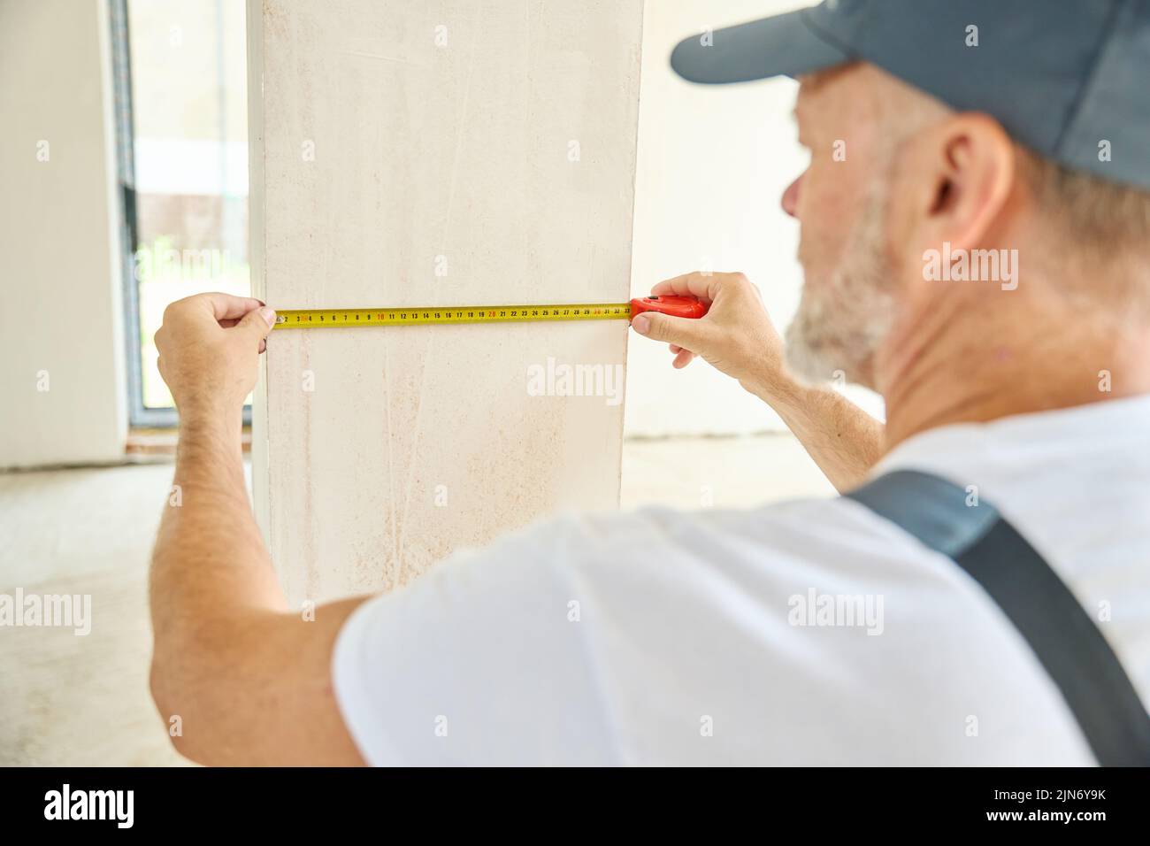 Close-up of builder measuring width of walls at construction site Stock Photo