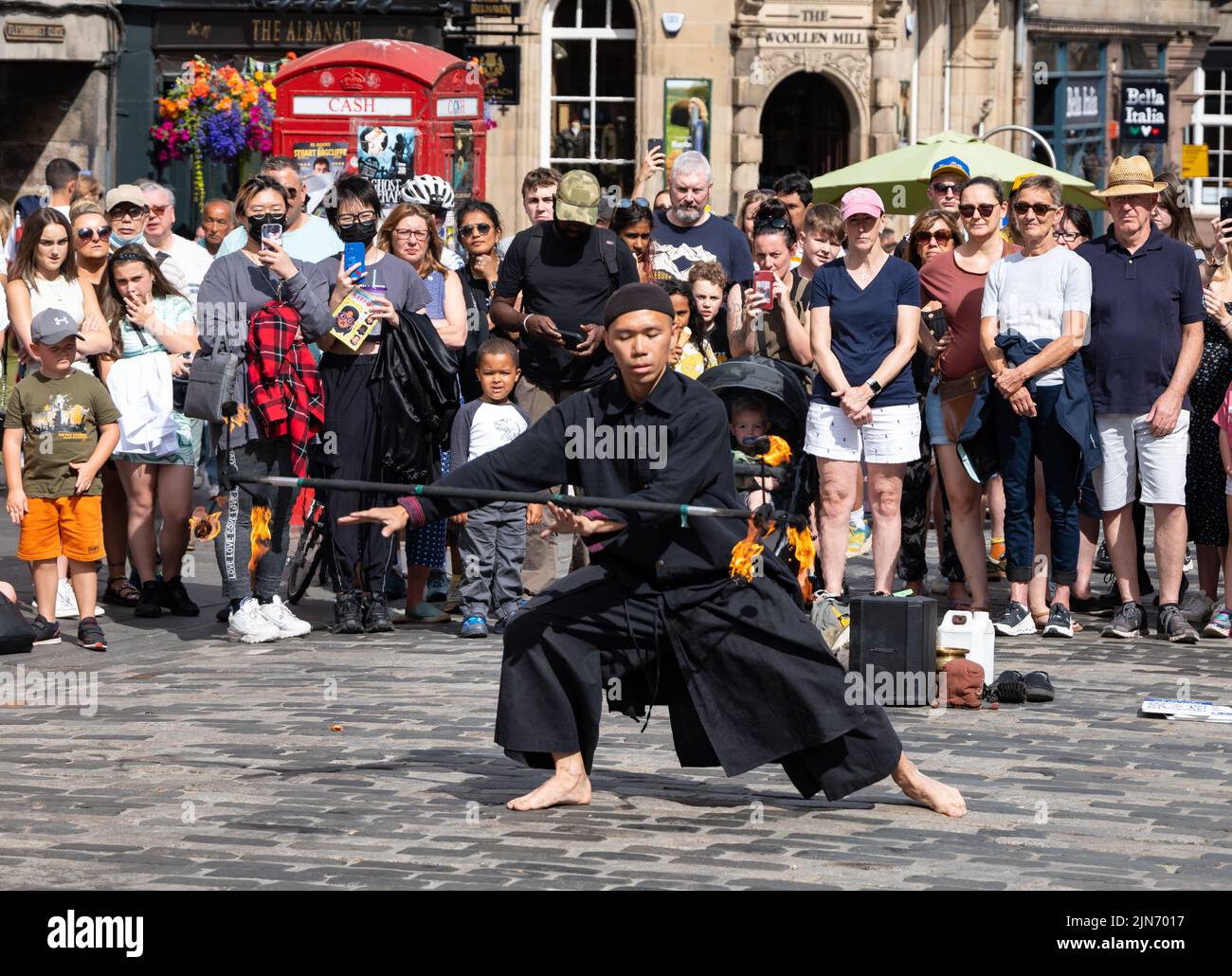 Royal Mile, Edinburgh, Scotland, UK, 9th August 2022. Edinburgh Festival Fringe street performer: a man performs for the crowd in the sunshine playing with fire. Credit: Sally Anderson/Alamy Live News Stock Photo