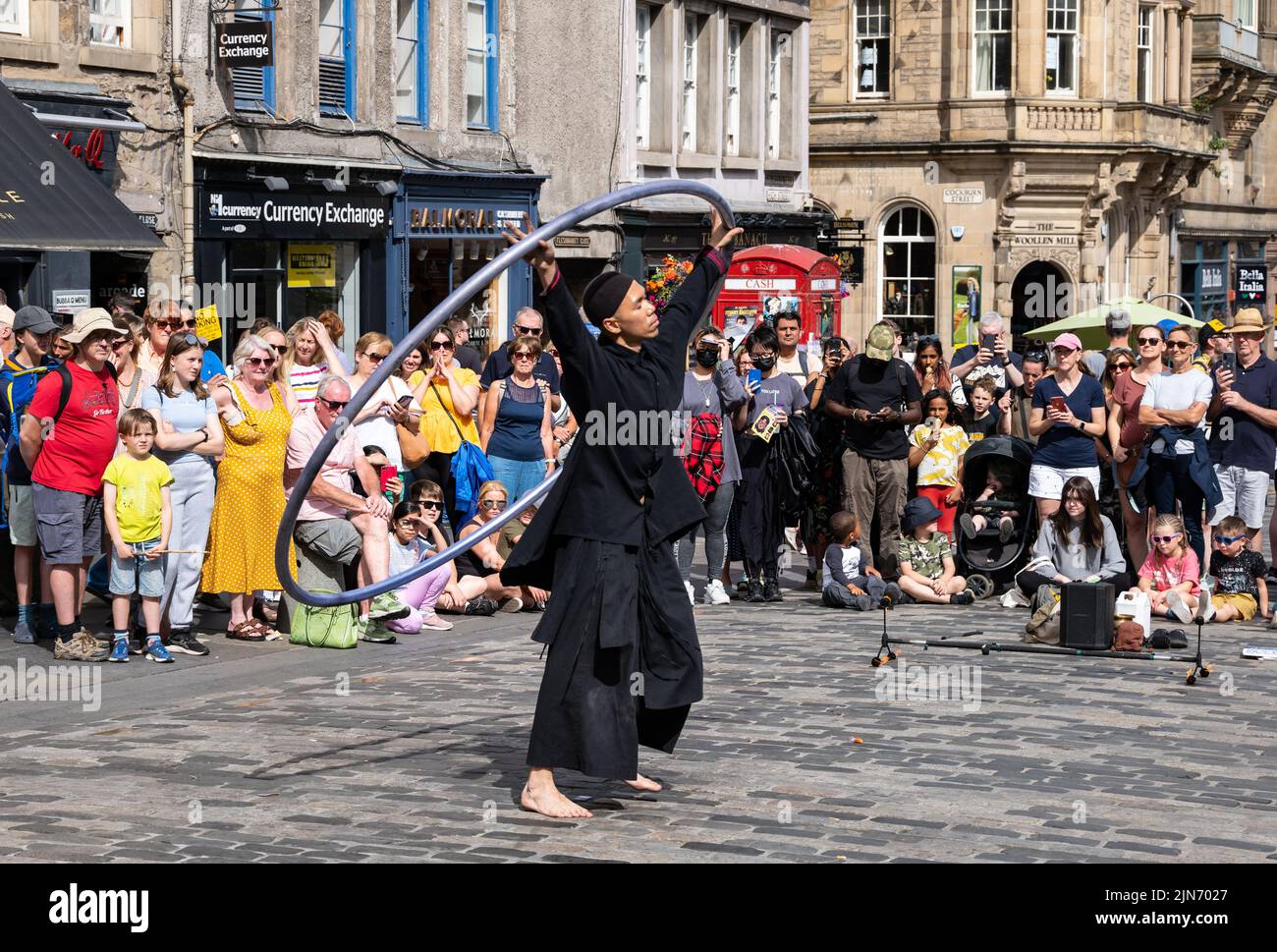 Royal Mile, Edinburgh, Scotland, UK, 9th August 2022. Edinburgh Festival Fringe street performer: a man performs acrobatci stunts for the crowd in the sunshine. Credit: Sally Anderson/Alamy Live News Stock Photo