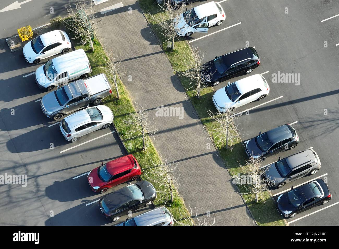 Aerial view of many colorful cars parked on parking lot with lines and