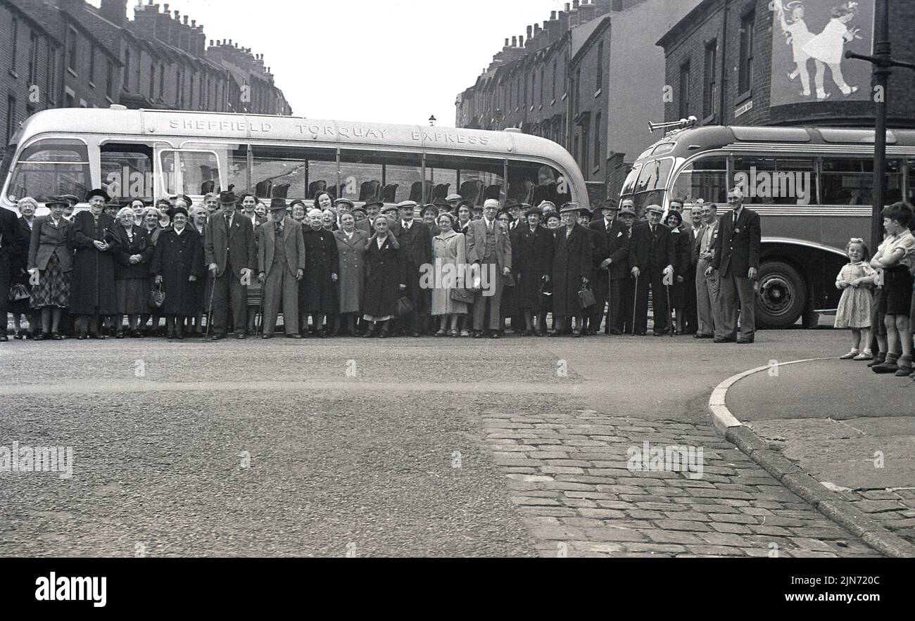 1950s, historical, coach trip, Sheffield to Toquay Express, England, UK. Passengers line-up in the street for a photo before the trip down south to the seaside resort of Torquay. Stock Photo
