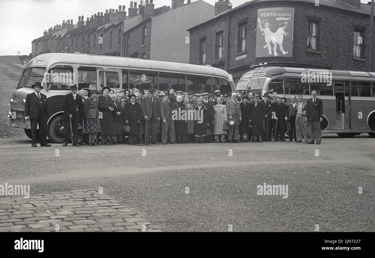 1950s, historical, coach trip, Sheffield to Toquay Express, England, UK. Passengers line-up in the street for a photo before the trip down south to the seaside resort of Torquay. Stock Photo