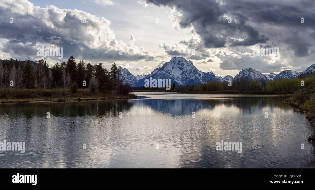 River surrounded by Trees and Mountains in American Landscape. Stock Photo