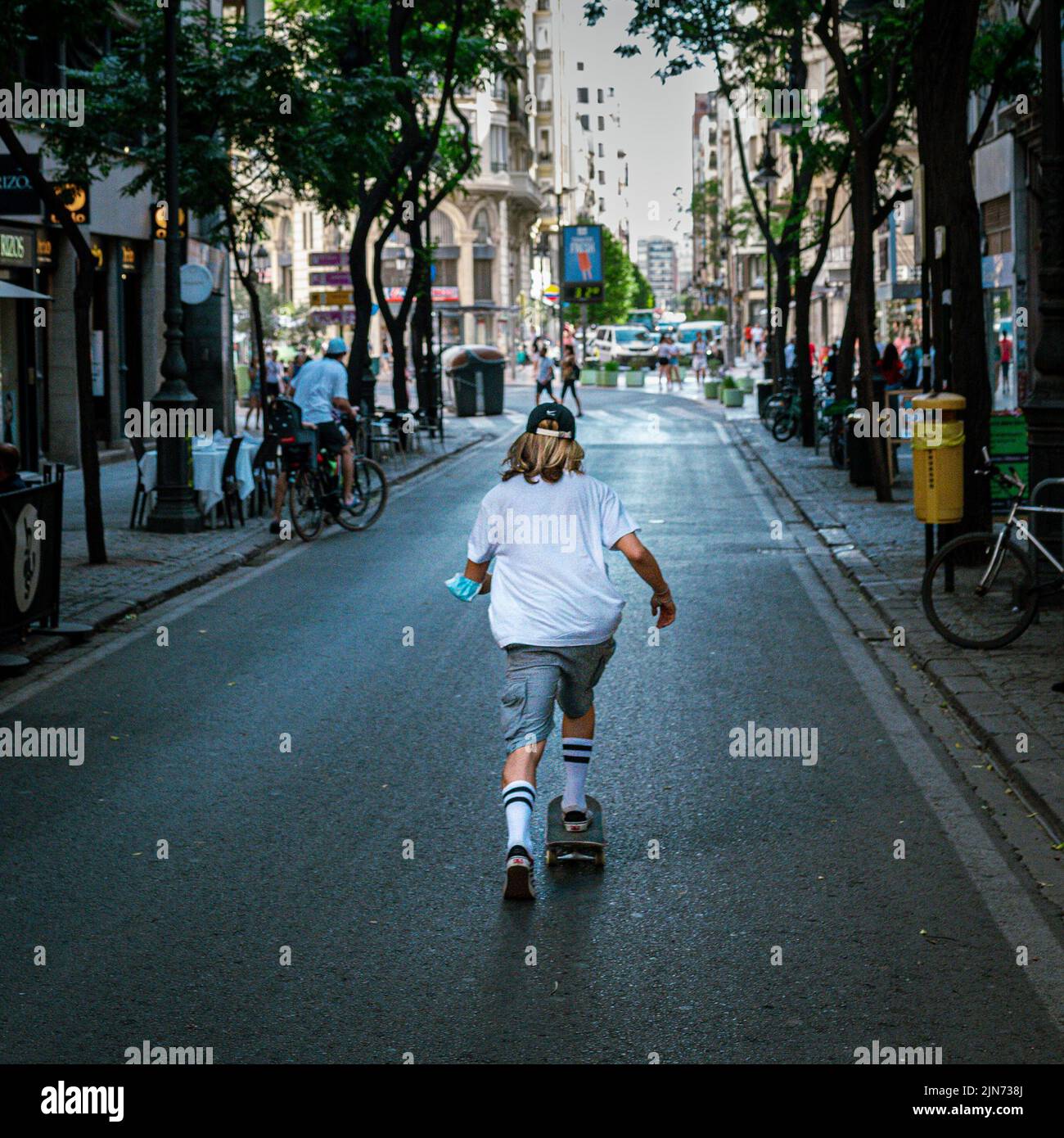 A skateboarder heading down an empty street in Valencia Stock Photo