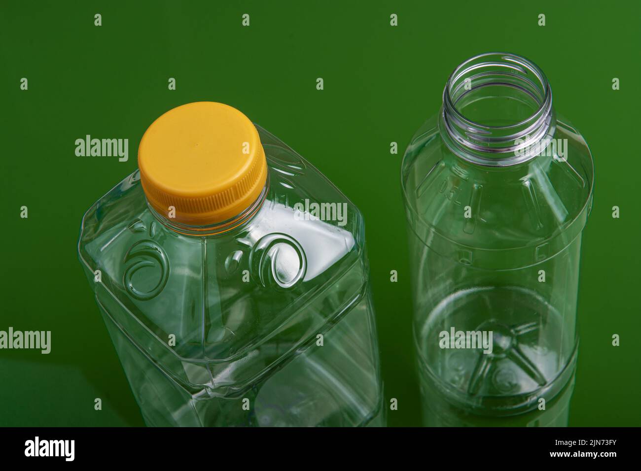 Two empty plastic bottles on a green background Stock Photo