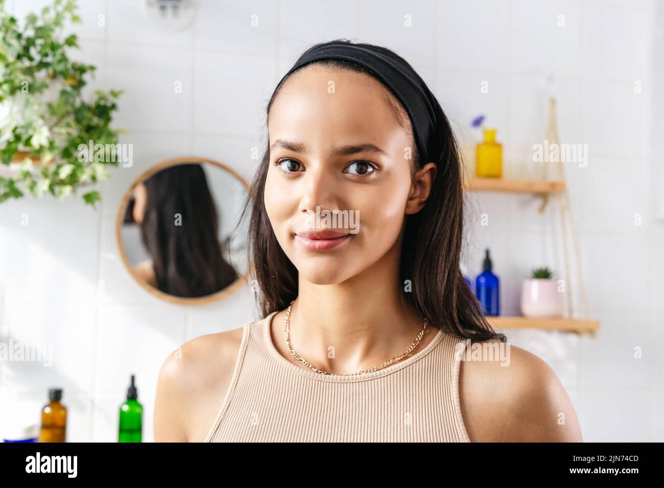 Close up beauty portrait of hispanic woman in bathroom. Confident young woman feeling positive and comfortable in her body. Woman's power. Wellness, skin care Stock Photo