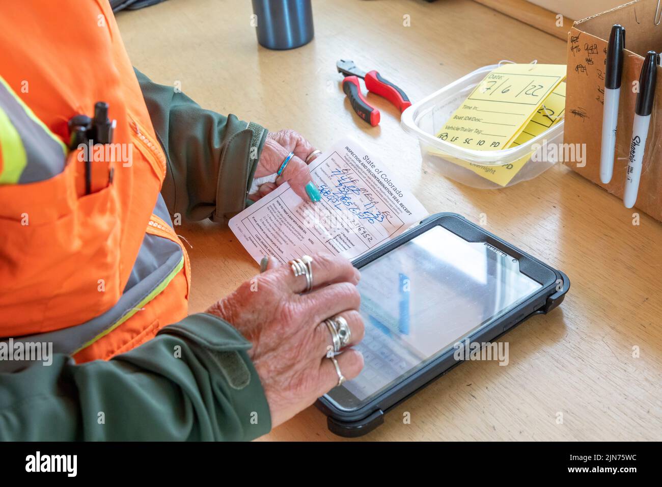 Gunnison, Colorado - Carol Soell, a boat inspector at Curecanti National Recreation Area, records information after inspecting a boat for invasive spe Stock Photo