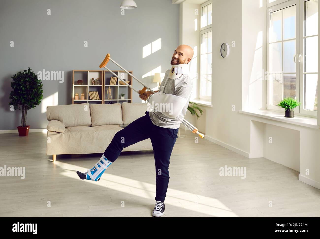 Man has fun during rehabilitation at home recovering from numerous physical injuries. Stock Photo