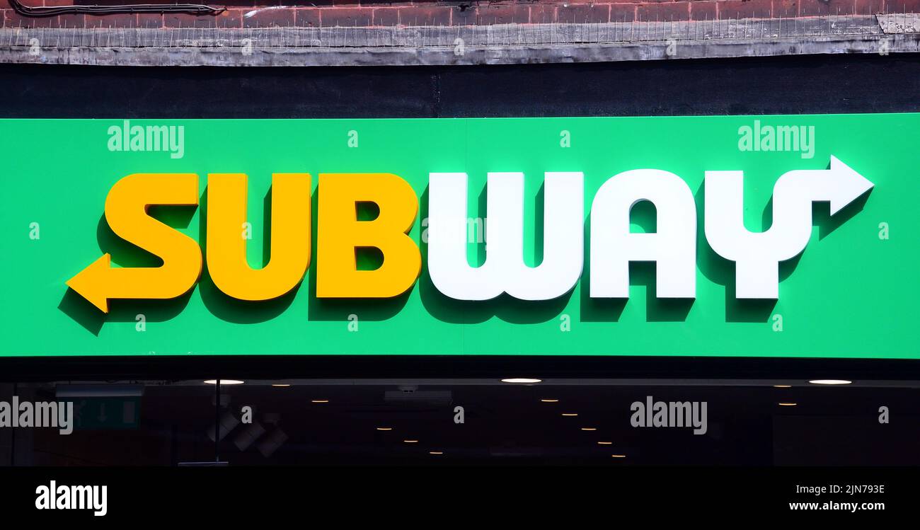 An exterior sign or signage or logo on the Subway shop or store, selling sandwiches, in central Manchester, United Kingdom, British Isles. Stock Photo