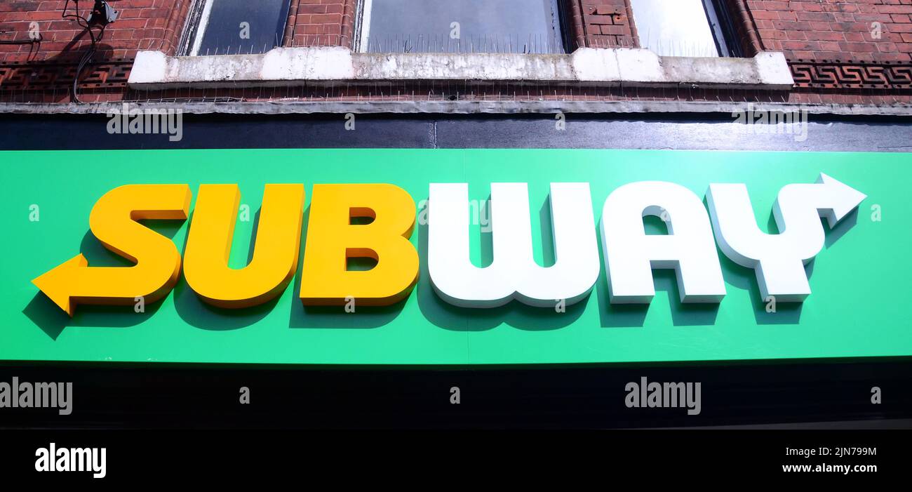 An exterior sign or signage or logo on the Subway shop or store, selling sandwiches, in central Manchester, United Kingdom, British Isles. Stock Photo