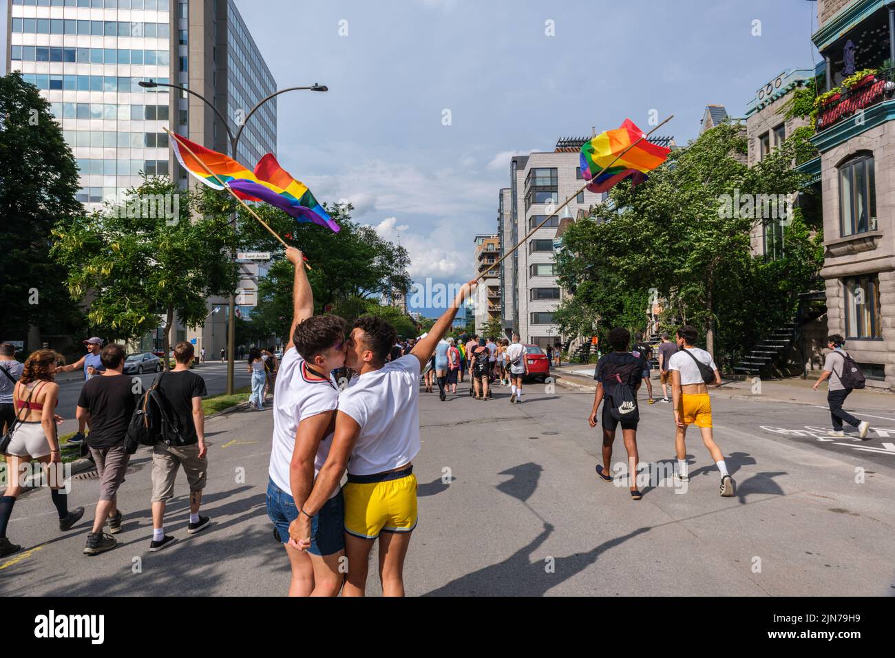 Montreal, CA - 7 August 2022: Two young men kiss during spontaneous gay pride march after official pride parade was cancelled Stock Photo