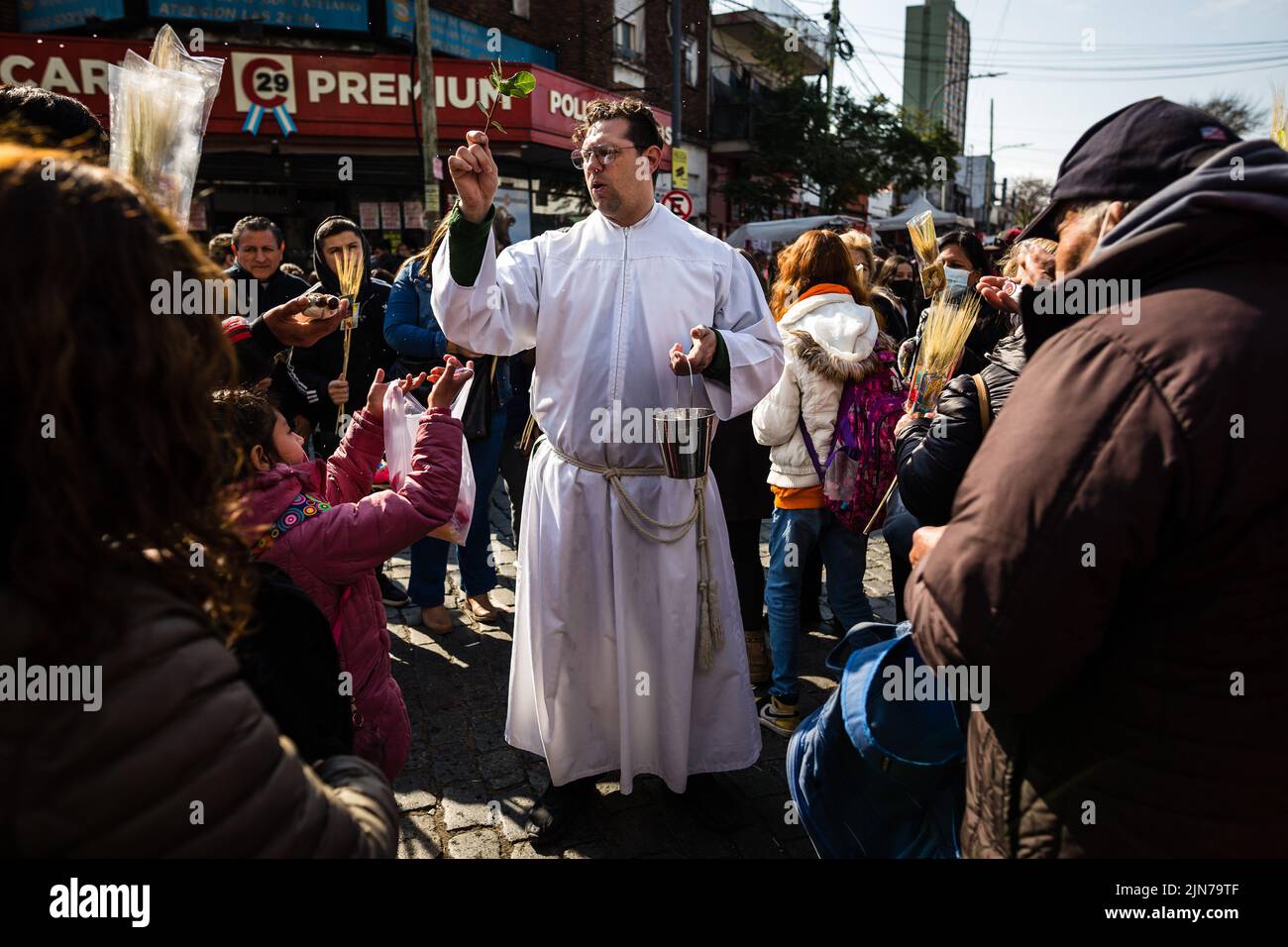 Buenos Aires, Argentina. 07th Aug, 2022. A priest in the street blesses a group of people meters from the temple of San Cayetano. After two years of pandemic, the great feast of San Cayetano was celebrated again in the church Santuario San Cayetano, in the cosmopolitan neighborhood Liniers of the city of Buenos Aires. As every August 7, many faithful could touch the image and venerate the Saint of Labor to ask for bread, peace and sustenance. Credit: SOPA Images Limited/Alamy Live News Stock Photo