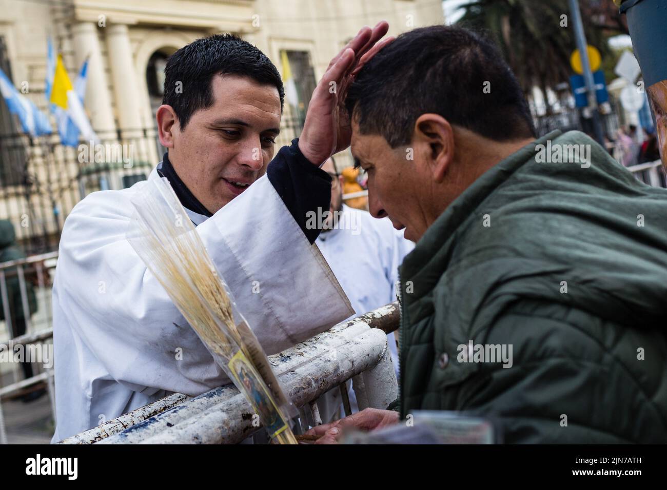 A priest blesses a devotee meters from the temple built in honor of the Saint of Labor. After two years of pandemic, the great feast of San Cayetano was celebrated again in the church Santuario San Cayetano, in the cosmopolitan neighborhood Liniers of the city of Buenos Aires. As every August 7, many faithful could touch the image and venerate the Saint of Labor to ask for bread, peace and sustenance. (Photo by Nacho Boullosa / SOPA Images/Sipa USA) Stock Photo