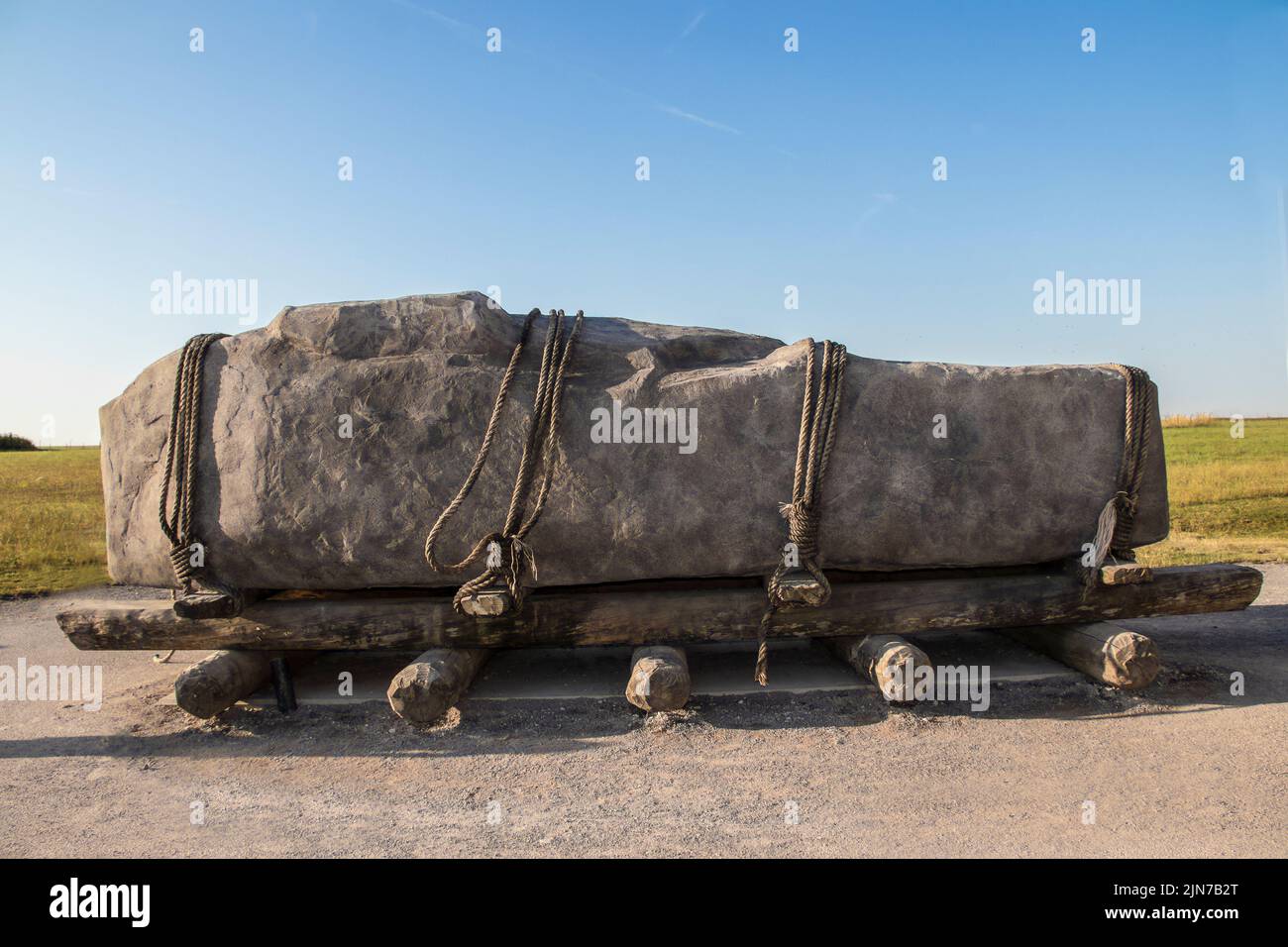 Standing stone horizontal on sledge with rollers  tied down with ropes like the stones at Stonehenge may have been moved Stock Photo