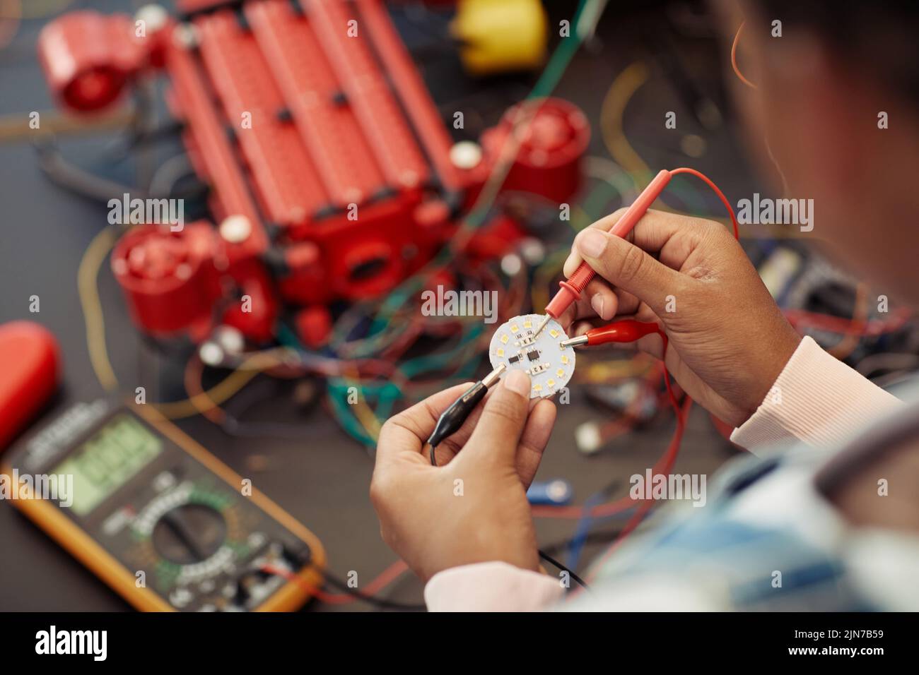 Close up of child building robot and wiring circuit board during engineering class at school, copy space Stock Photo