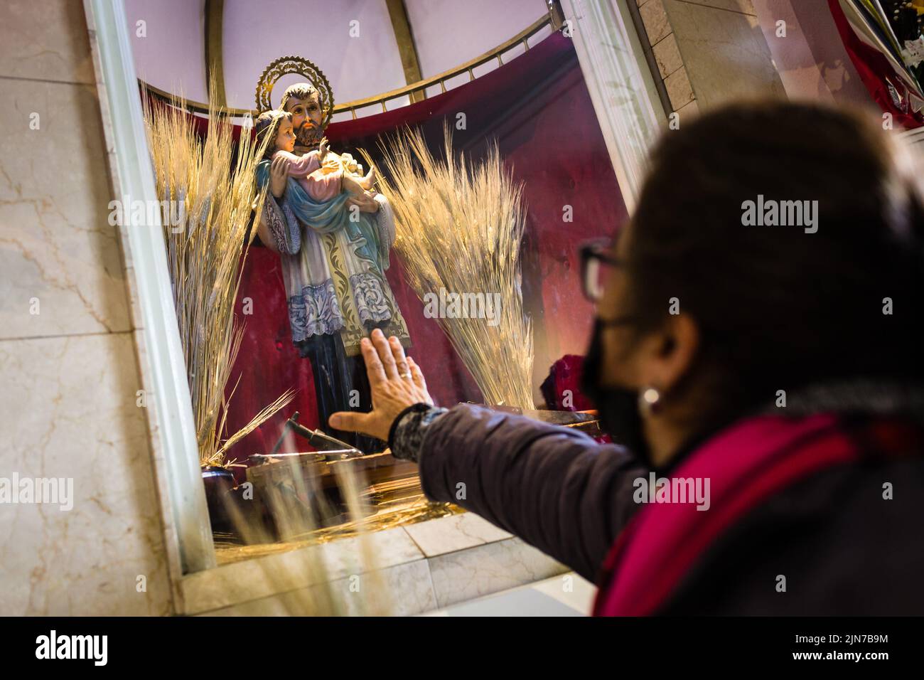 Buenos Aires, Argentina. 7th Aug, 2022. A woman approaches her hand to the image of San Cayetano while begging the Saint for bread, peace and work. After two years of pandemic, the great feast of San Cayetano was celebrated again in the church Santuario San Cayetano, in the cosmopolitan neighborhood Liniers of the city of Buenos Aires. As every August 7, many faithful could touch the image and venerate the Saint of Labor to ask for bread, peace and sustenance. (Credit Image: © Nacho Boullosa/SOPA Images via ZUMA Press Wire) Stock Photo