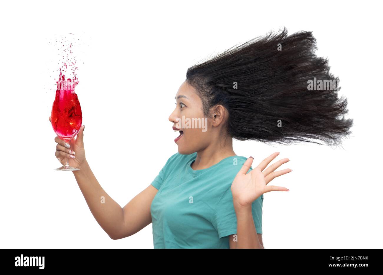 An emotional woman is looking at a glass with a drink, isolated on a white background Stock Photo