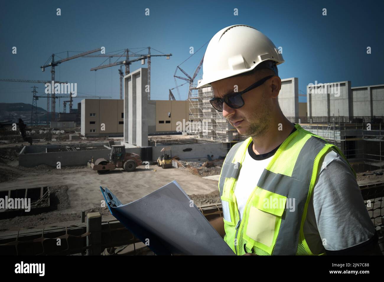 Construction site engineer opposite industrial background Stock Photo