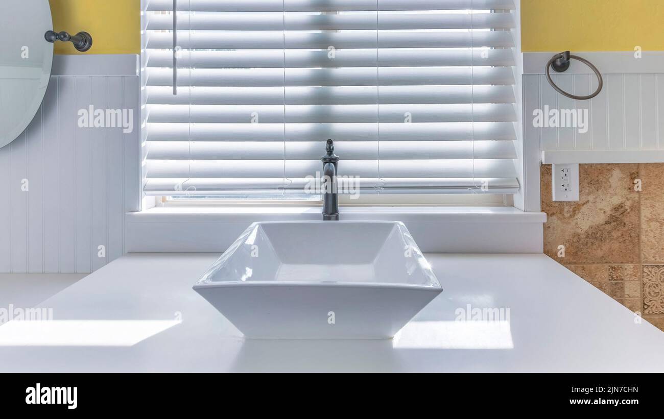 Panorama White ceramic vessel sink with antique faucet fixture against the  window with blinds. Bathroom interior with sloped ceiling and white wooden  Stock Photo - Alamy