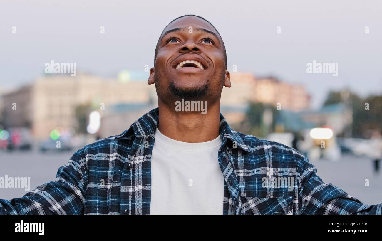 African American happy young guy in casual t-shirt isolated in city ...