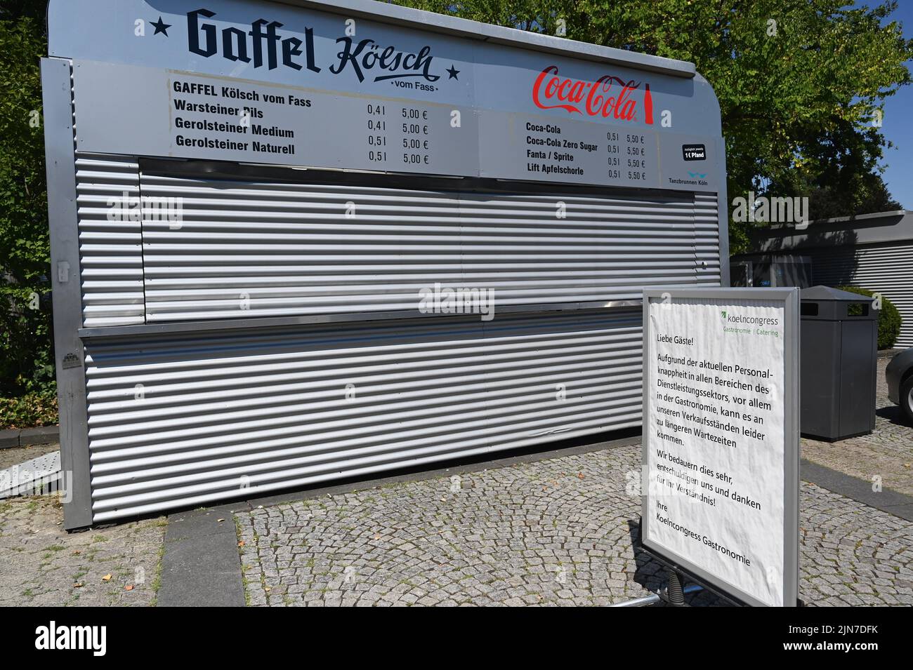 Cologne, Germany. 09th Aug, 2022. A sign at the open air location Cologne Tanzbrunnen indicates that there may be longer waiting times due to staff shortages and staff shortages in the service sector. Credit: Horst Galuschka/dpa/Alamy Live News Stock Photo
