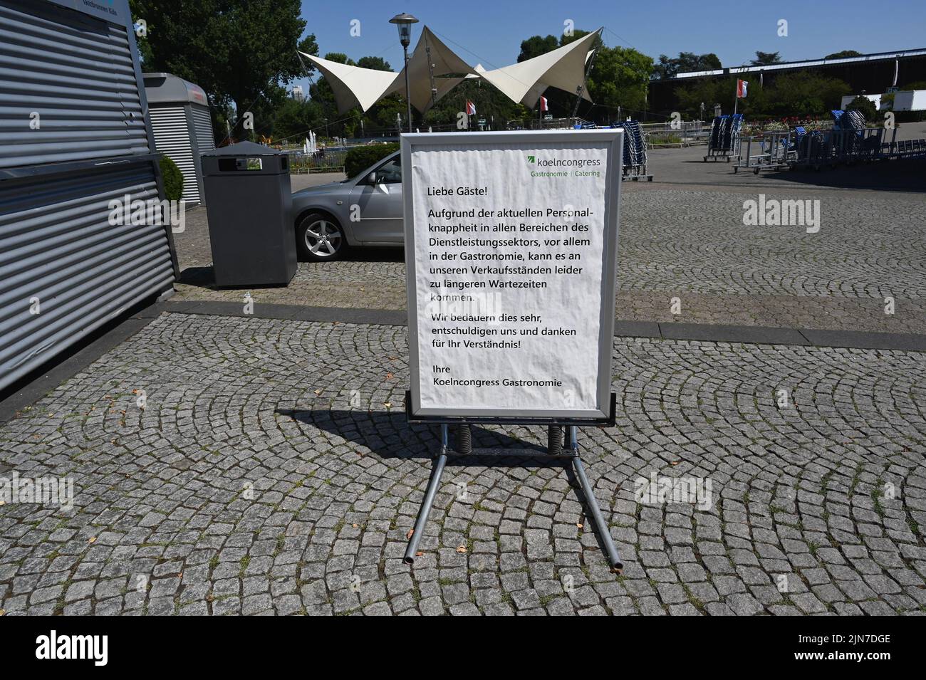 Cologne, Germany. 09th Aug, 2022. A sign at the open air location Cologne Tanzbrunnen indicates that there may be longer waiting times due to staff shortages and staff shortages in the service sector. Credit: Horst Galuschka/dpa/Horst Galuschka dpa/Alamy Live News Stock Photo
