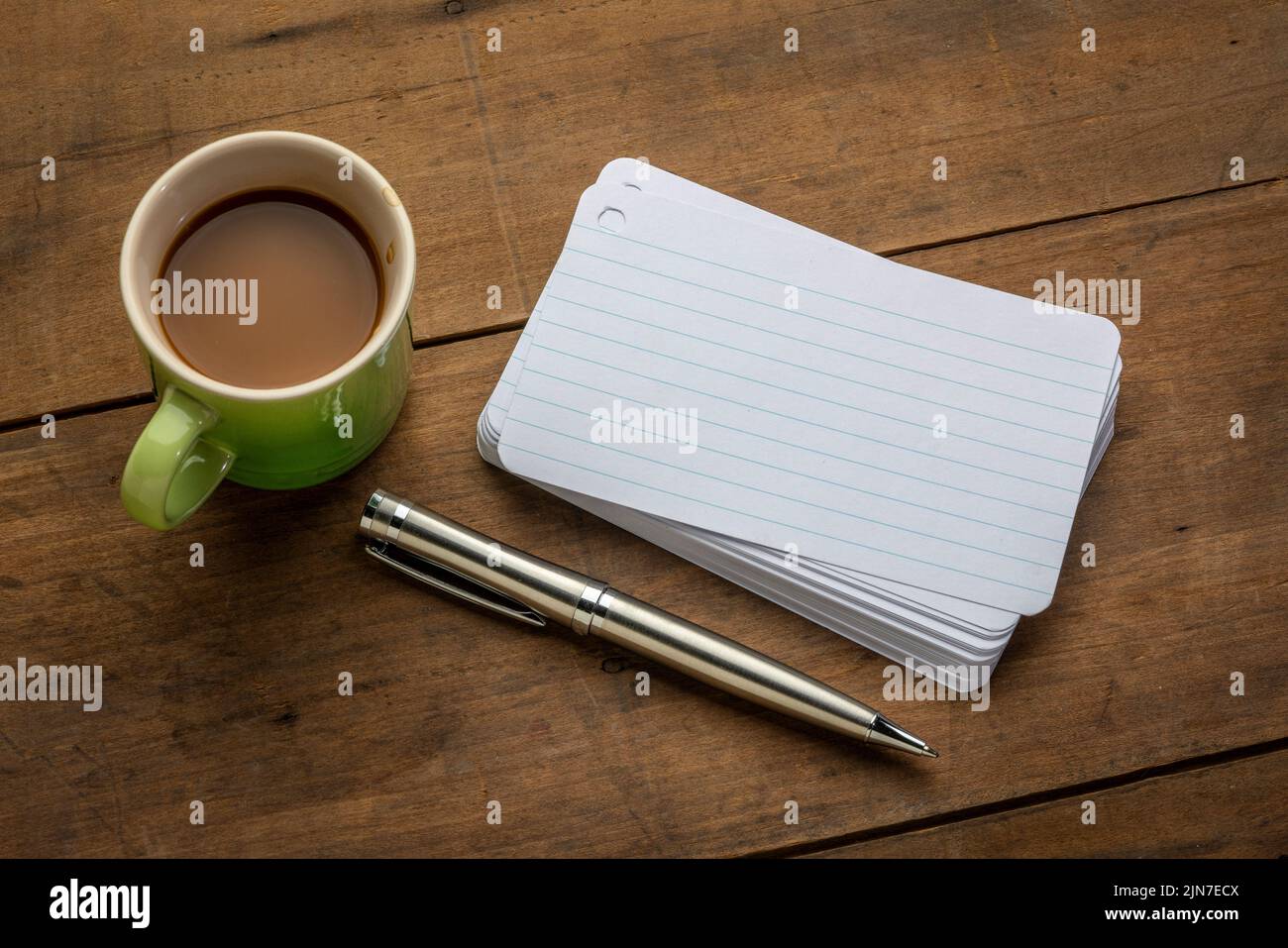 a stack of blank index cards with a cup of coffee and  a pen against textured bark paper Stock Photo