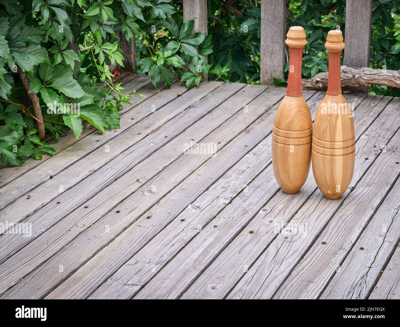 pair of Indian exercise clubs on a wooden deck - functional fitness concept, clubs are particularly valuable for grip strength, shoulder work, and rot Stock Photo