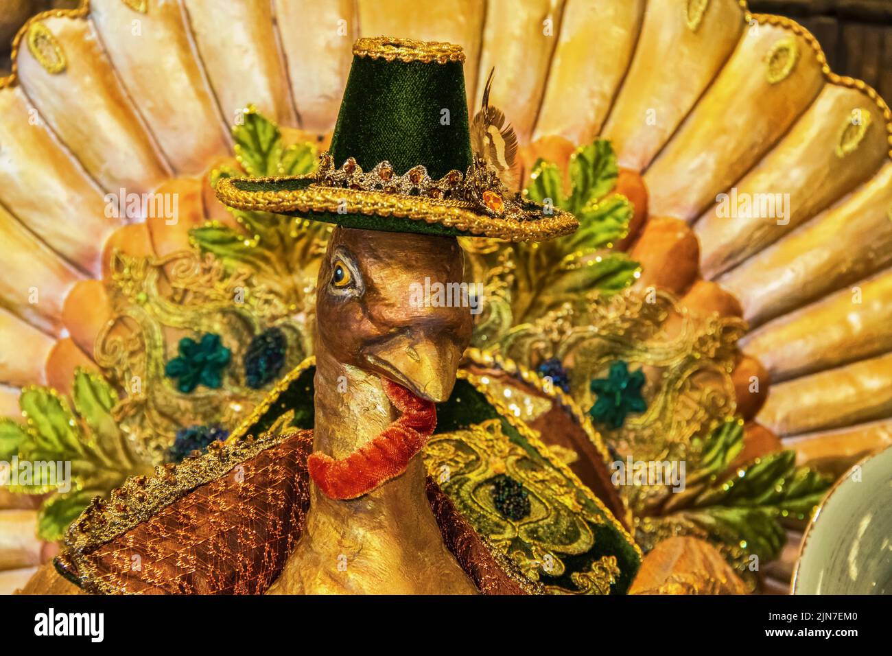 Time to give thanks - Closeup of head of Thanksgiving decorative turkey with ornate trim and pilgrim hat - Selective focus - Tail is blurred and trim Stock Photo