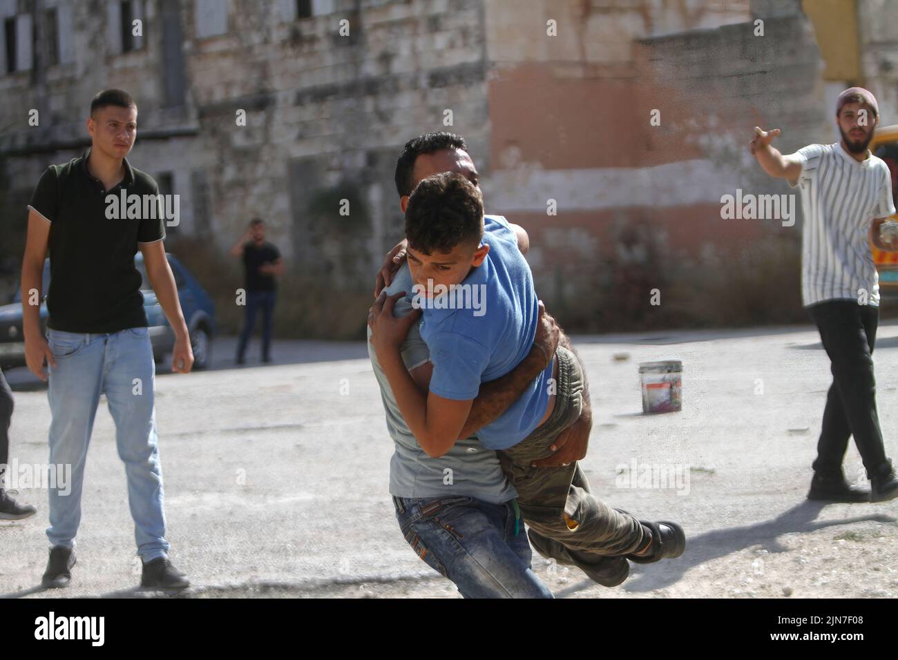 Nablus, Palestine. 02nd Aug, 2022. A Palestinian man seen carrying an injured protester during the clashes with Israeli army forces after a raid in the Old City of Nablus in the occupied West Bank, the Palestinian Ministry of Health said that 3 Palestinians killed during the raid. Credit: SOPA Images Limited/Alamy Live News Stock Photo