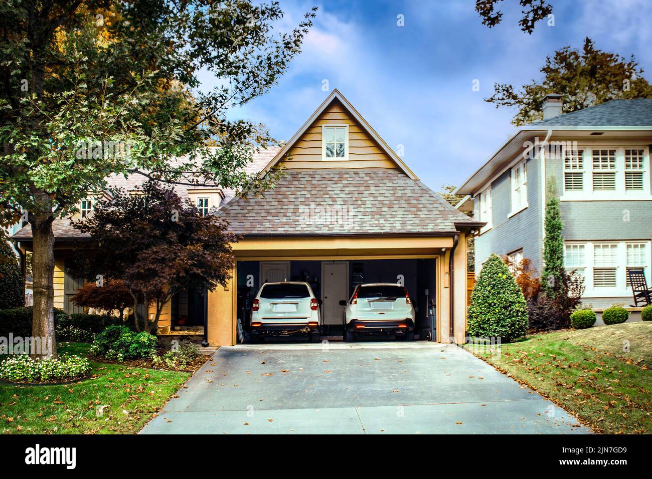 Two car garage open with two white SUVS parked inside on autumn day Stock Photo Alamy