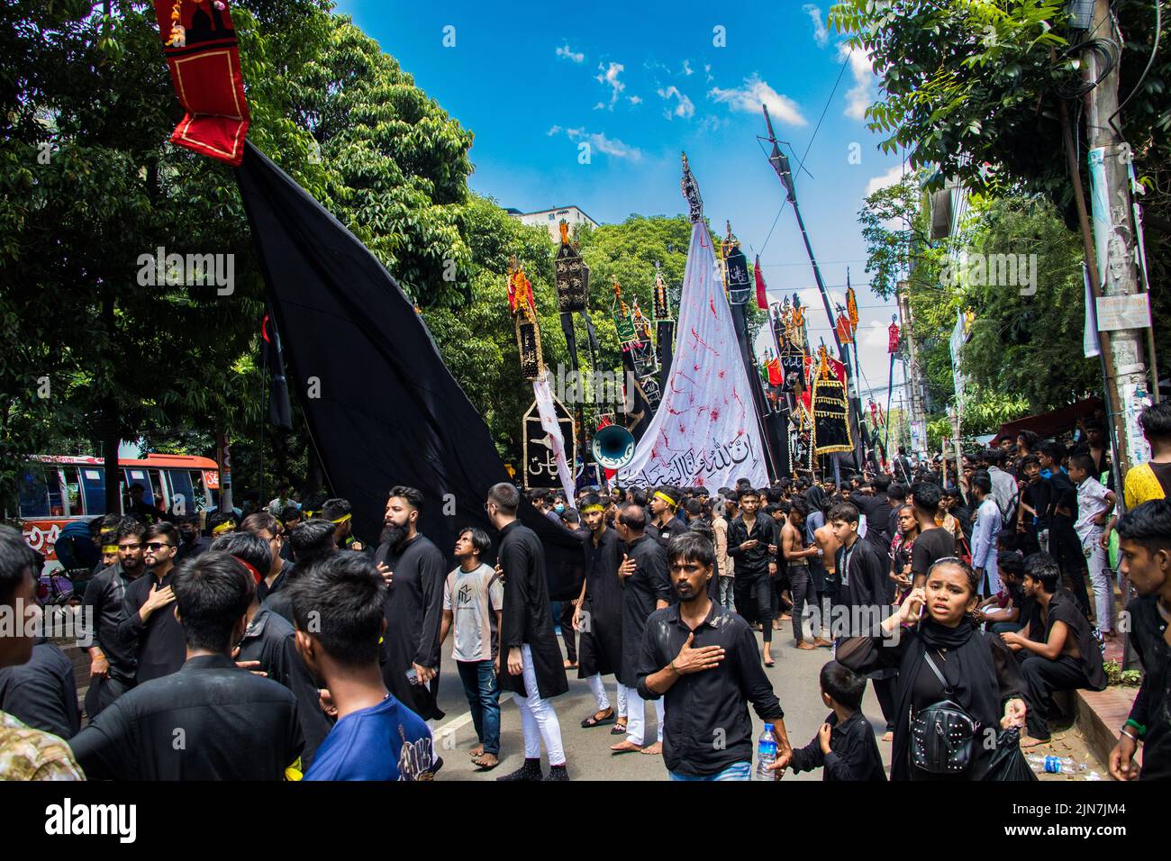 Bangladeshi Shia Muslims march and carry the flags and Tazia during a