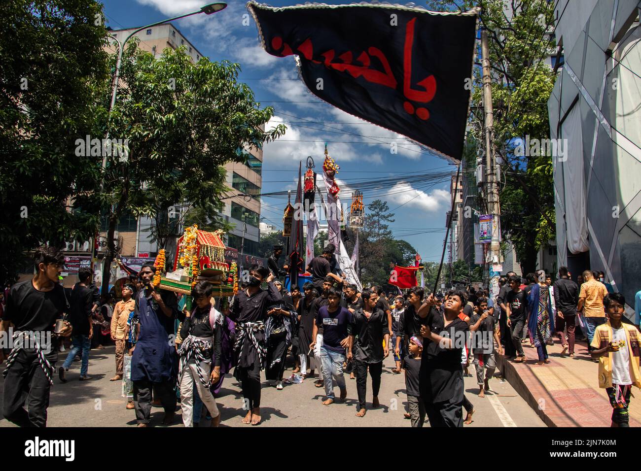 Bangladeshi Shia Muslims march and carry the flags and Tazia during a