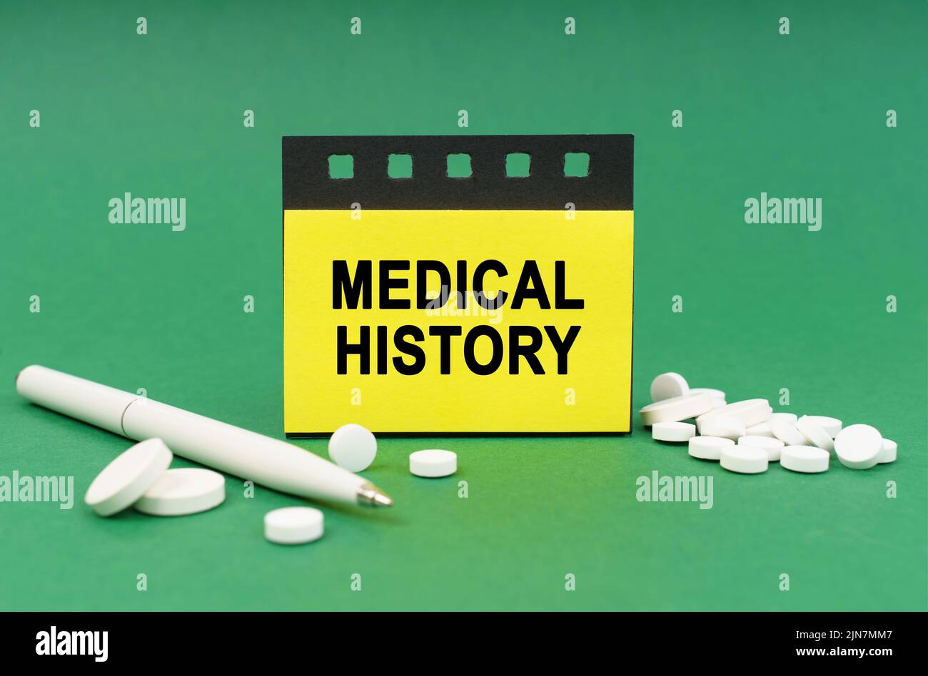 Medical concept. On the green surface are tablets, a pen and stickers