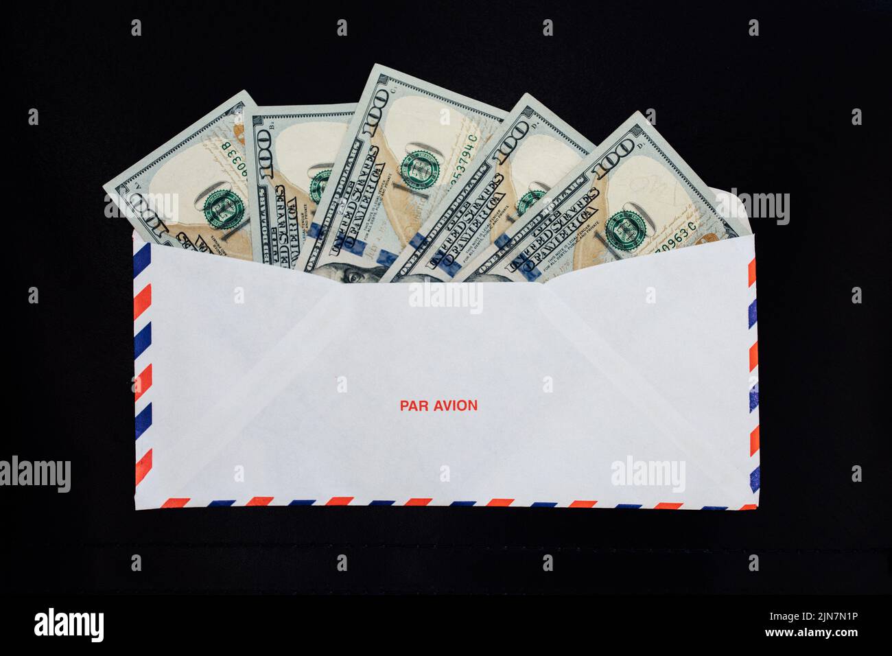 five one hundred American dollar bills in Par Avion airmail envelope Stock Photo