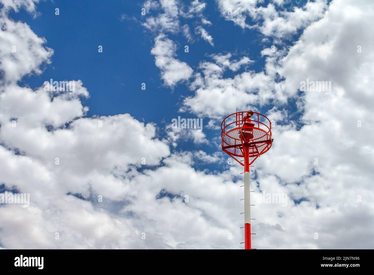 Red and white signal tower at a airport with a cloudy sky Stock Photo