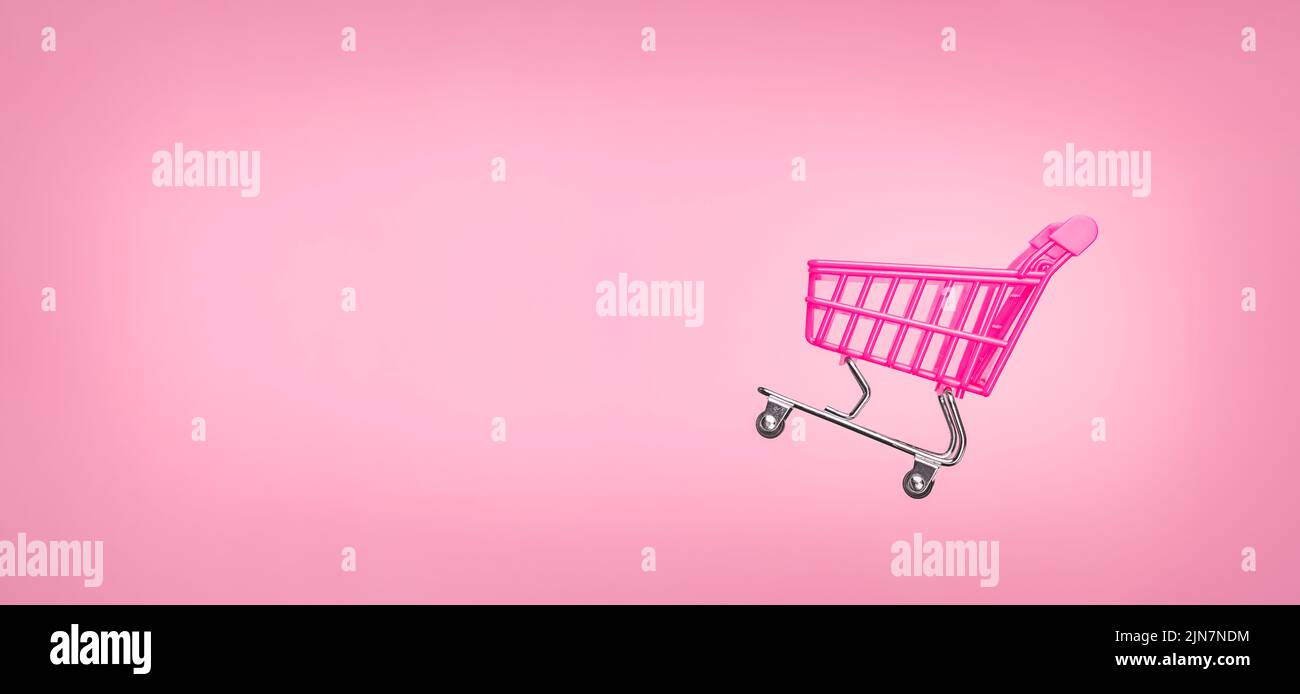 Sale cart shop banner E online. Empty trolley cart isolated pink background. Pink shopping trolley supermarket concept. Banner pink concept sales Stock Photo