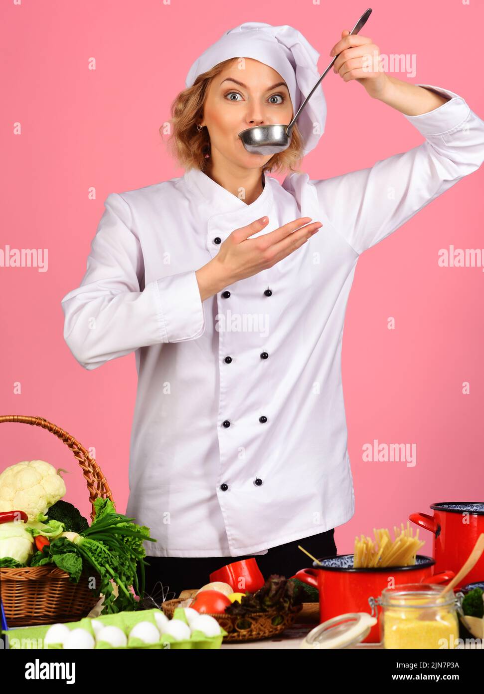 Female chef in white uniform with ladle spoon. Cooking and professional culinary. Food preparation. Stock Photo