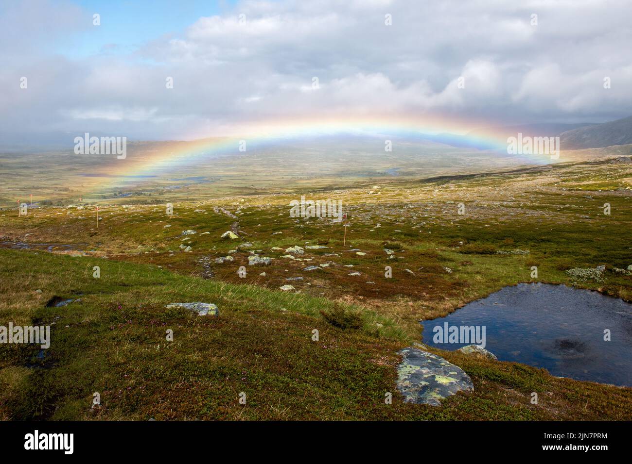 A rainbow above a hiking trail between Helags Mountain Station and Valastugan mountain hut, Sweden Stock Photo