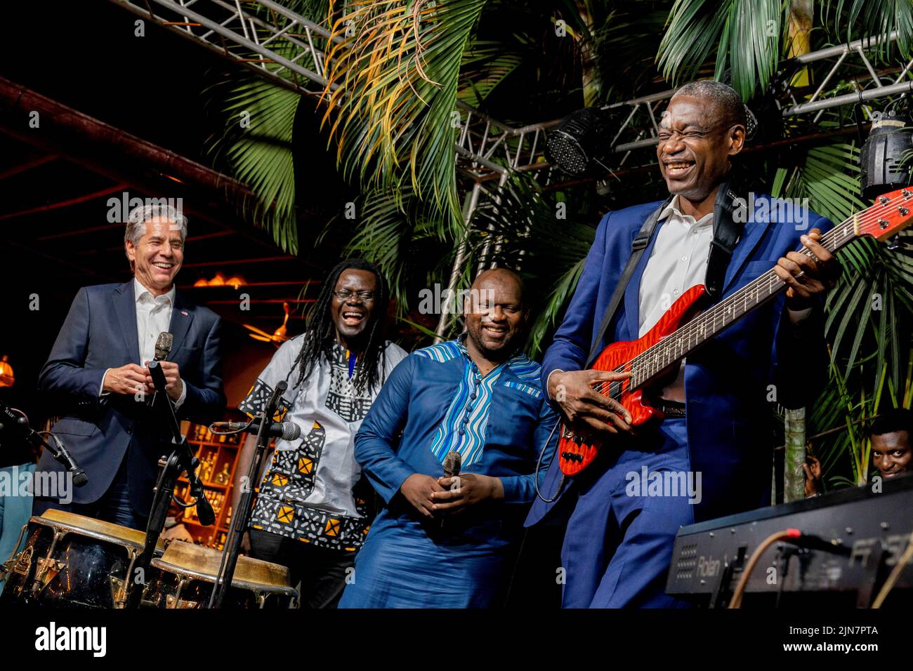 Former NBA basketball superstar and Congo native Dikembe Mutombo, accompanied by U.S. Secretary of State Antony Blinken, laughs as he tries to play a few notes on the guitar as they take the stage with the “Rainbow Band” to say a few words at Villa Kilimanjaro in Kinshasa, Democratic Republic of the Congo, August 9, 2022. Andrew Harnik/Pool via REUTERS Stock Photo