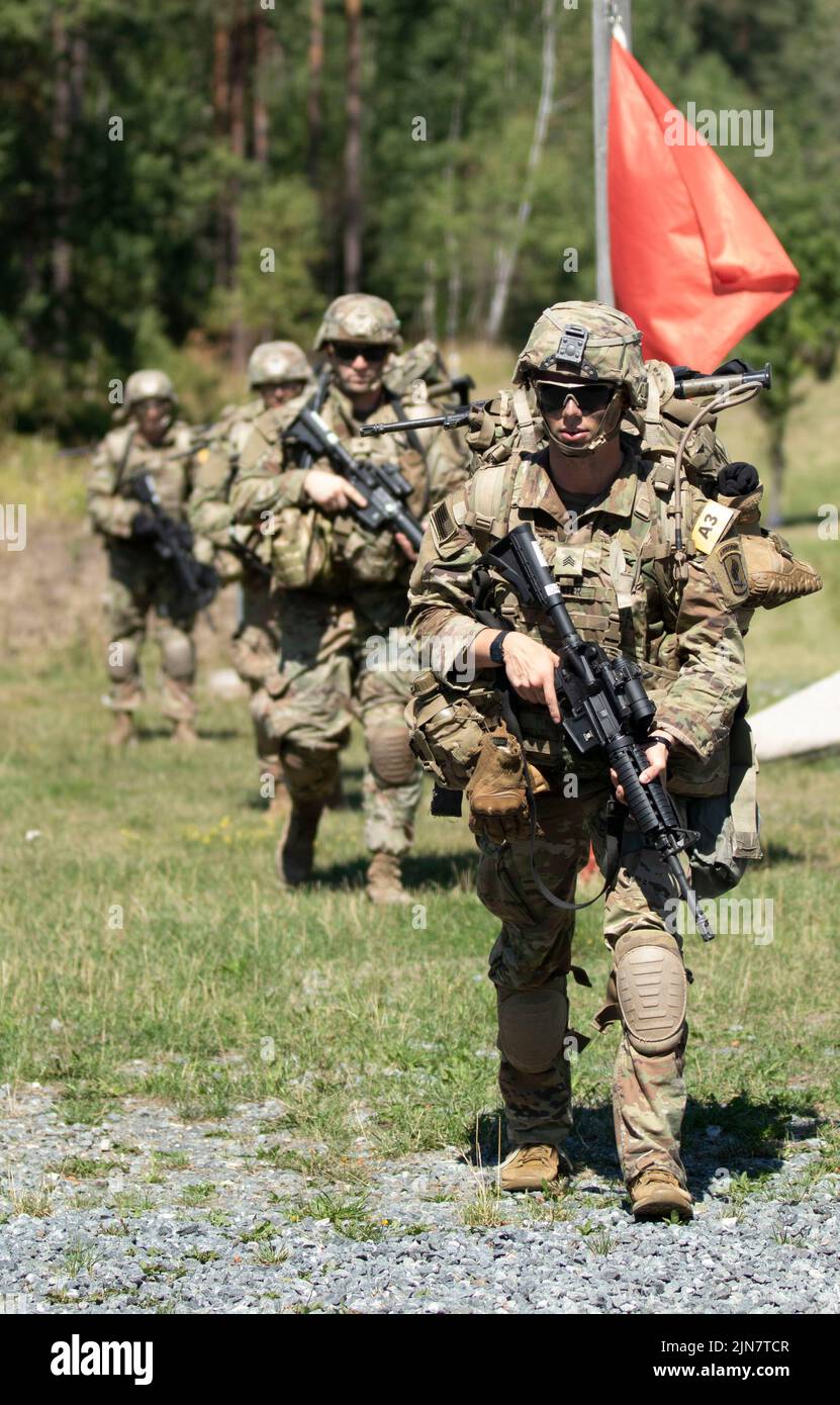 U.S. Army Sgt. Sebastian Poynter, assigned to the Southern European Task Force (SEATAF) steps off for a road march during the 2022 U.S. Army Europe and Africa Best Squad Competition on Grafenwoehr Training Area, Germany Aug. 9, 2022. Teams from across USAREUR-AF test their tactical proficiency, communication, and overall cohesion as they compete for the title of Best Squad. Winners of this competition will advance to represent USAREUR-AF at the U.S. Army Best Squad Competition at Fort Bragg, North Carolina later this year. Stock Photo