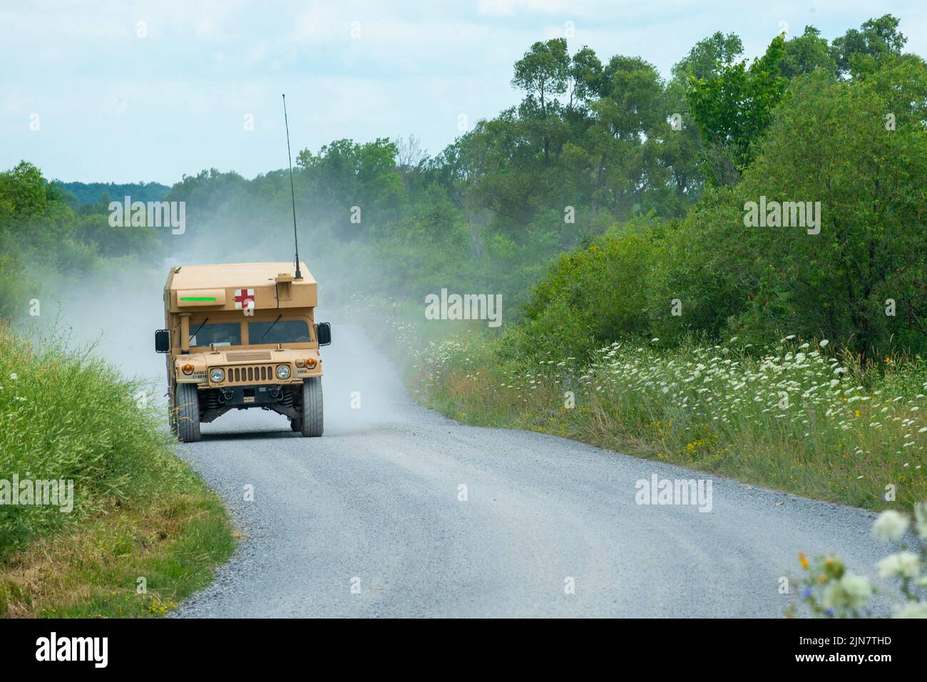 An M997A3 tactical Humvee ambulance races down a gravel road toward a casualty transfer point on Fort Drum, NY, July 21, 2022. (U.S. Army photo by Sgt. 1st Class Darron Salzer, First Army Division East) Stock Photo