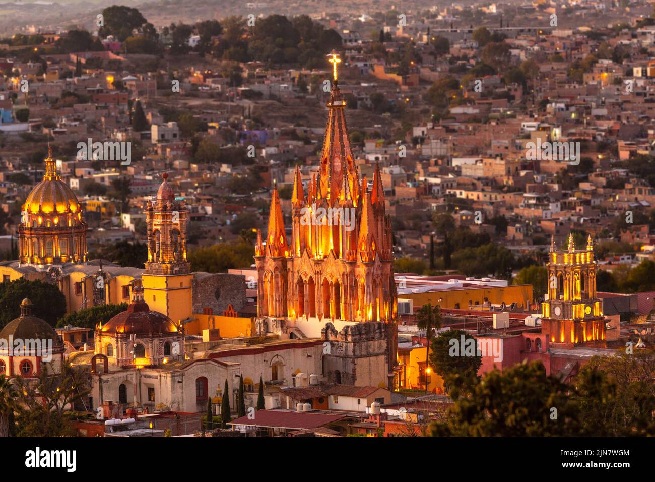 Colorful sunset over the Parroquia de San Miguel Arcangel and San Francisco church steeples in the historic district viewed from the hillside neighborhood of Los Balcones in San Miguel de Allende, Mexico. Stock Photo