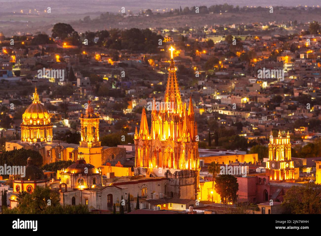 Colorful sunset over the Parroquia de San Miguel Arcangel and San Francisco church steeples in the historic district viewed from the hillside neighborhood of Los Balcones in San Miguel de Allende, Mexico. Stock Photo