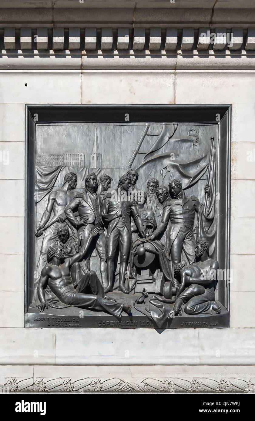 London, UK- July 4, 2022: Trafalgar Square. Closeup of black mural sculpture set in white marble pedestal of Nelson's Column depicts scene of naval ba Stock Photo