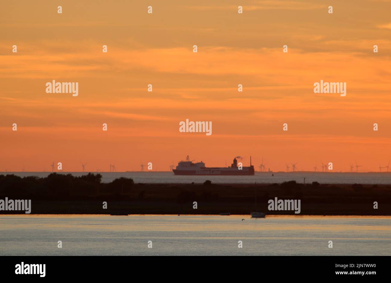 View from Plover Hill on Lancashire coast over the River Lune estuary  and Sunderland Point to a Stena line freight ferry at sunset 9th August 2022. Stock Photo