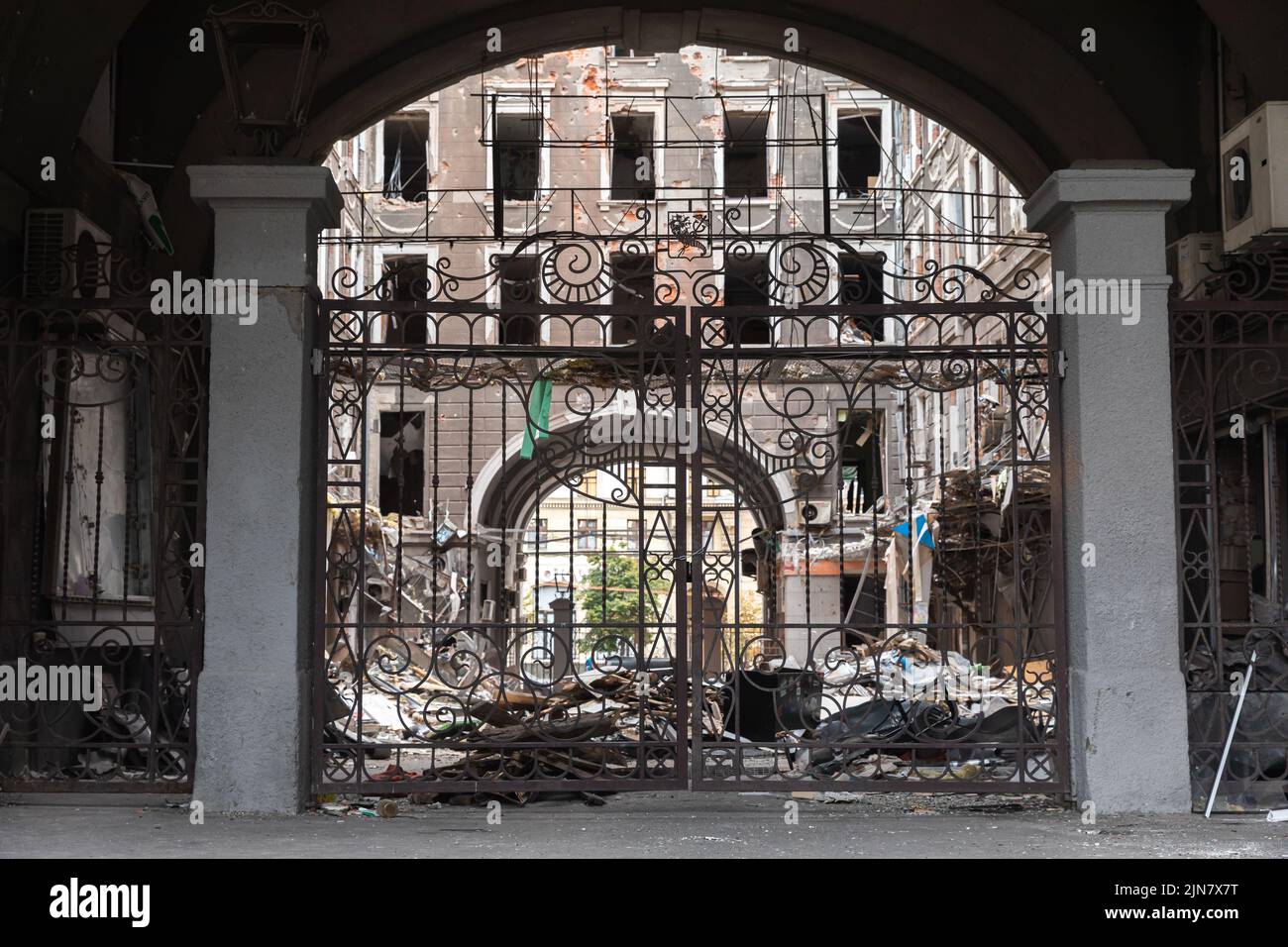 Kharkiv, Ukraine. 1st Aug, 2022. A decorative wrought-iron fence in the courtyard of the damaged building. Destroyed building in historical downtown in Kharkiv, Ukraine - 1 Aug 2022 (Credit Image: © Mykhaylo Palinchak/SOPA Images via ZUMA Press Wire) Stock Photo