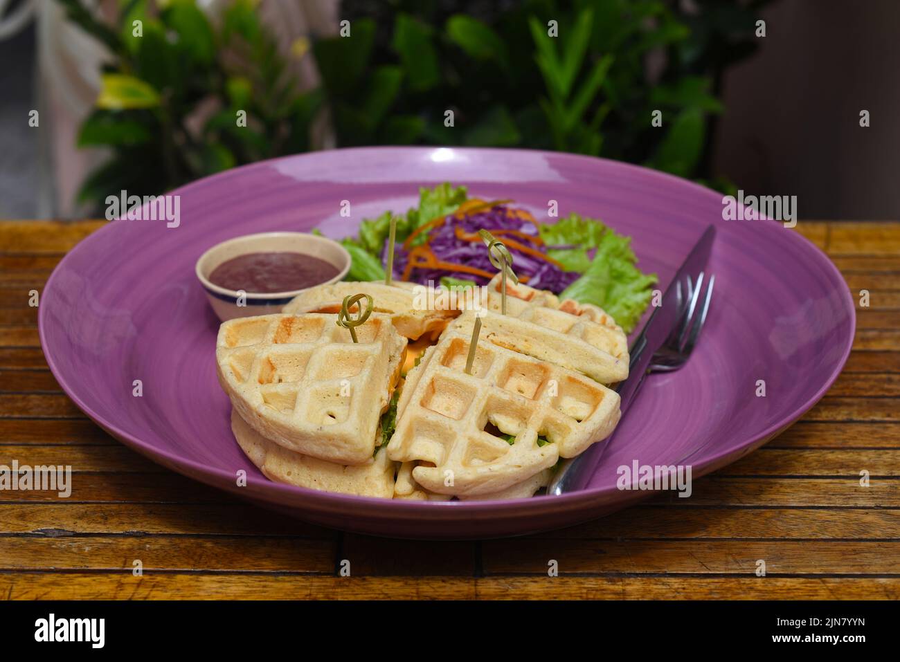 Belgium waffles with pan fried chicken on purple plate closeup Stock